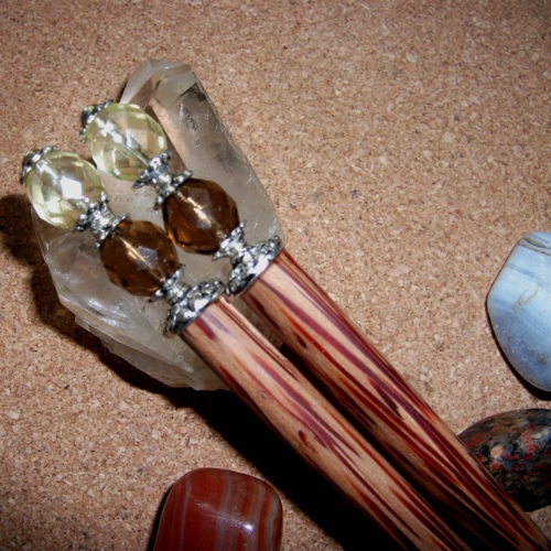 A pair ofCoconut hairsticks with Topaz and lemon crystals handmade by Longhaired Jewels